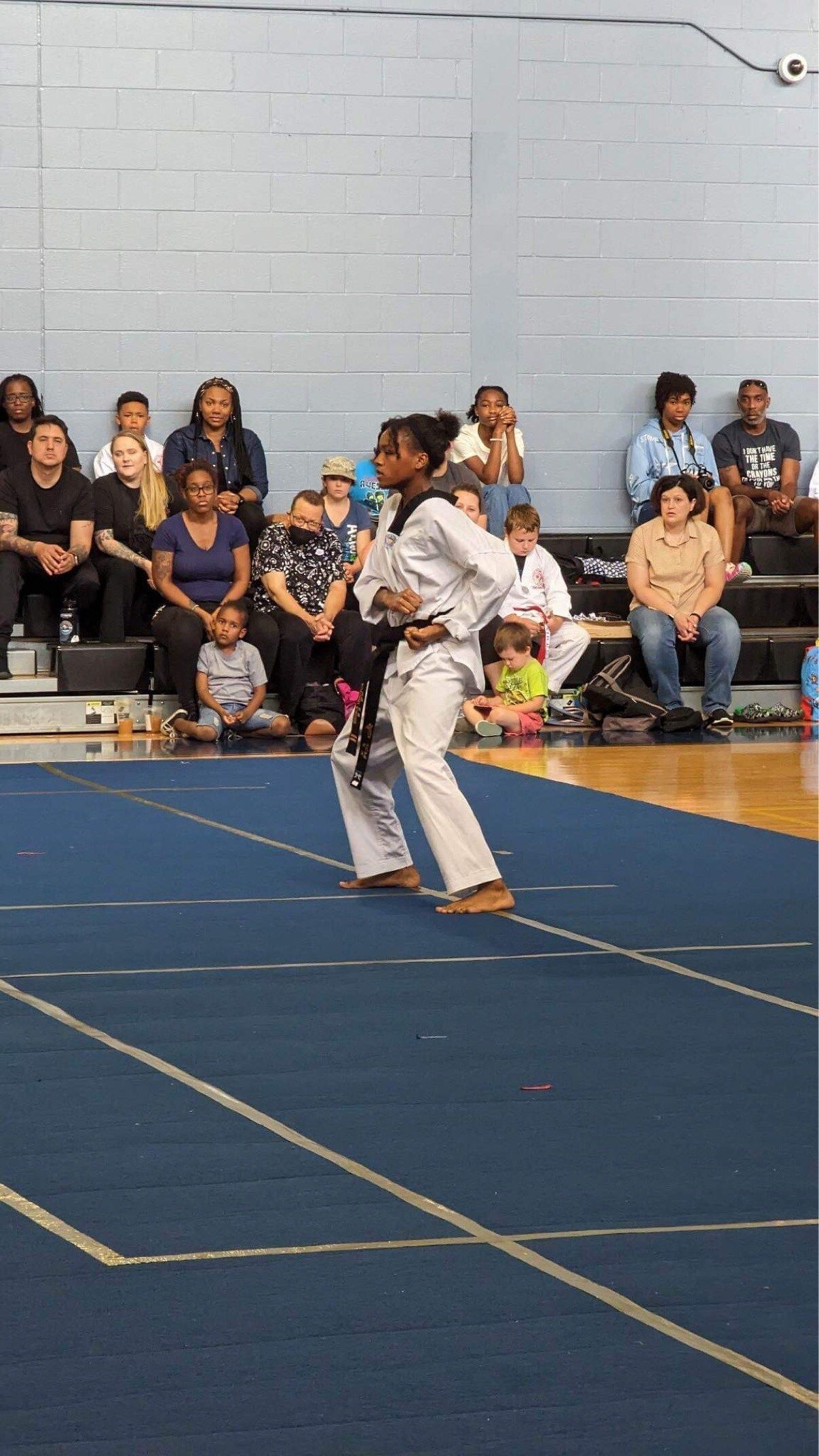 A woman is practicing martial arts in front of a crowd