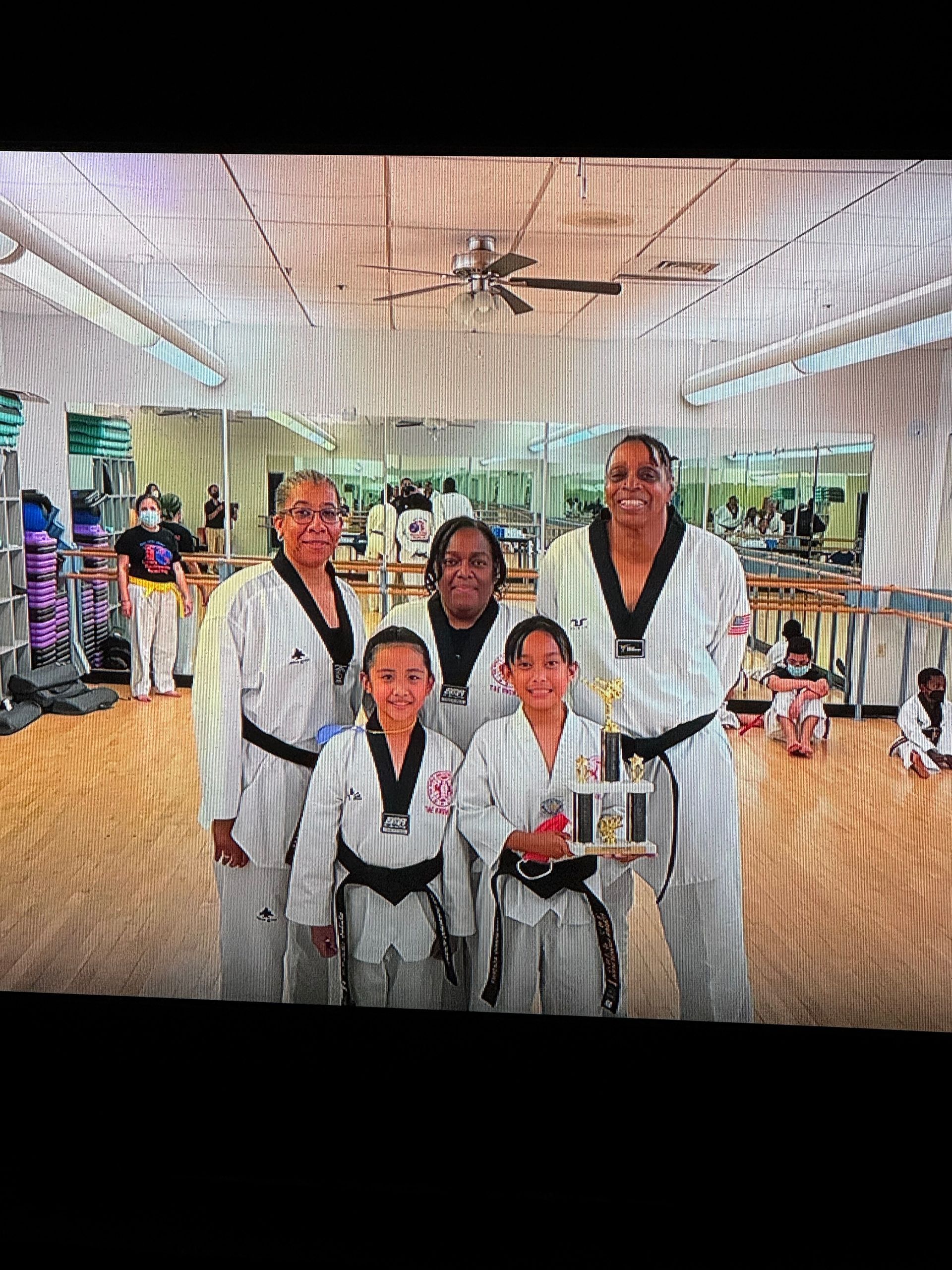 A group of people are posing for a picture in a gym.