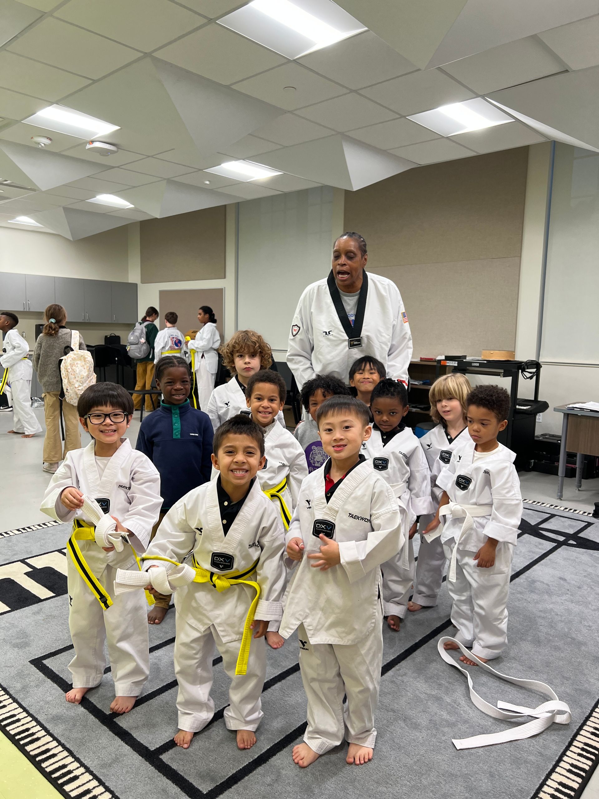 A group of young boys are posing for a picture with a man in a karate uniform