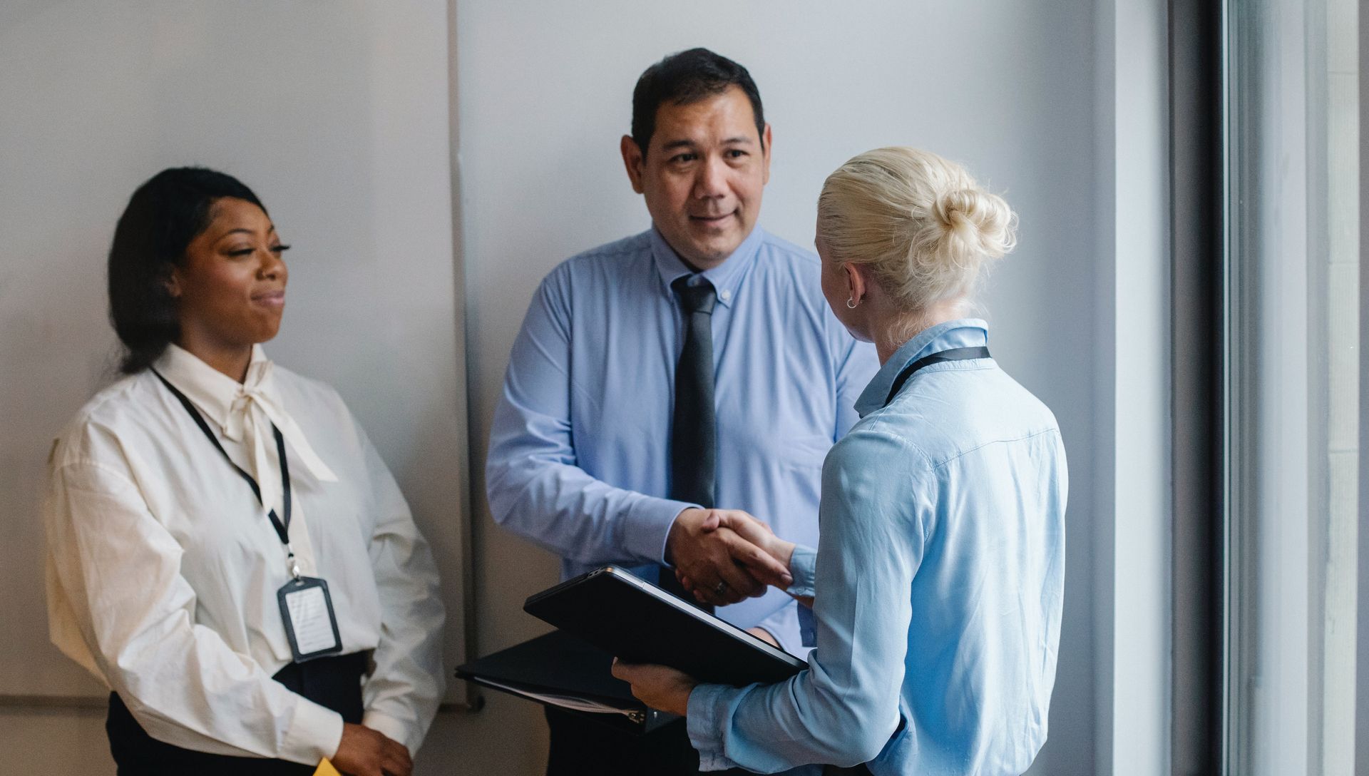 A group of people are shaking hands in an office.