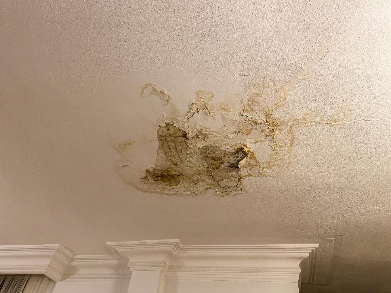 A large, dark brown water stain with bubbling texture.