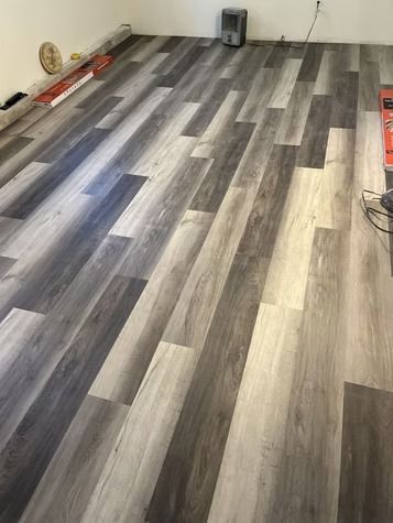 A room with newly installed gray-toned luxury vinyl plank flooring.