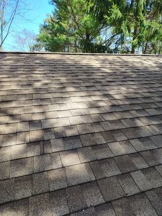A textured, brown asphalt shingle roof viewed from a slight angle.