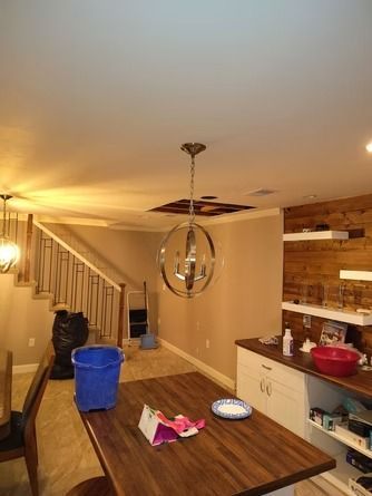A dining area with a wooden table, a chandelier.