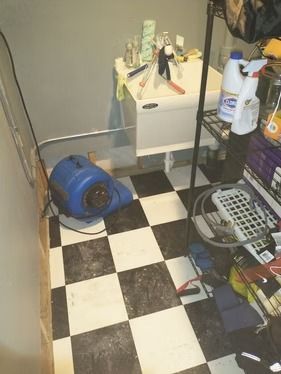 A blue air blower dries a utility sink area with a black-and-white checkered floor and a wire storage rack.