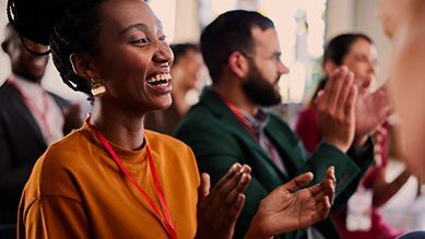 A group of people are sitting in a room clapping their hands.
