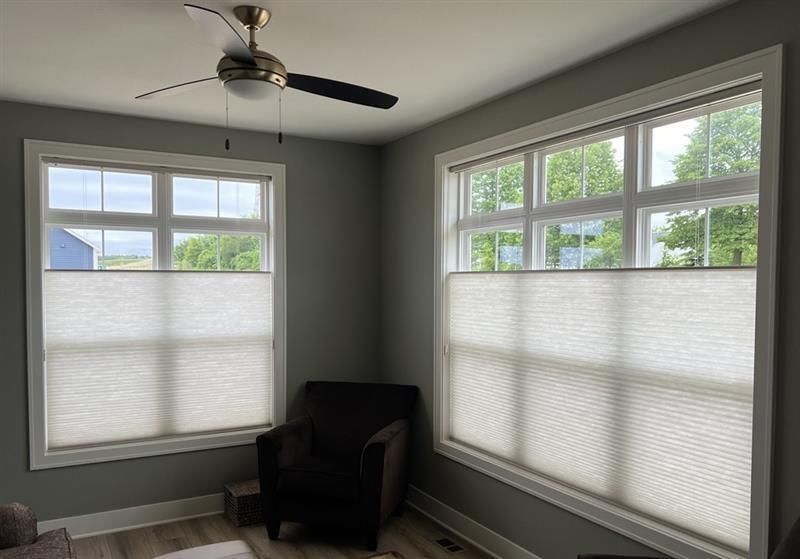 A bedroom with a large bed and lots of windows