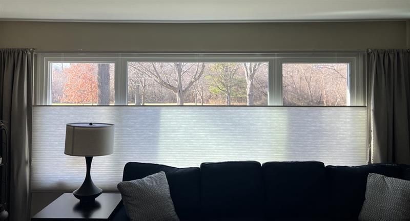 A close up of a white pleated blind on a window