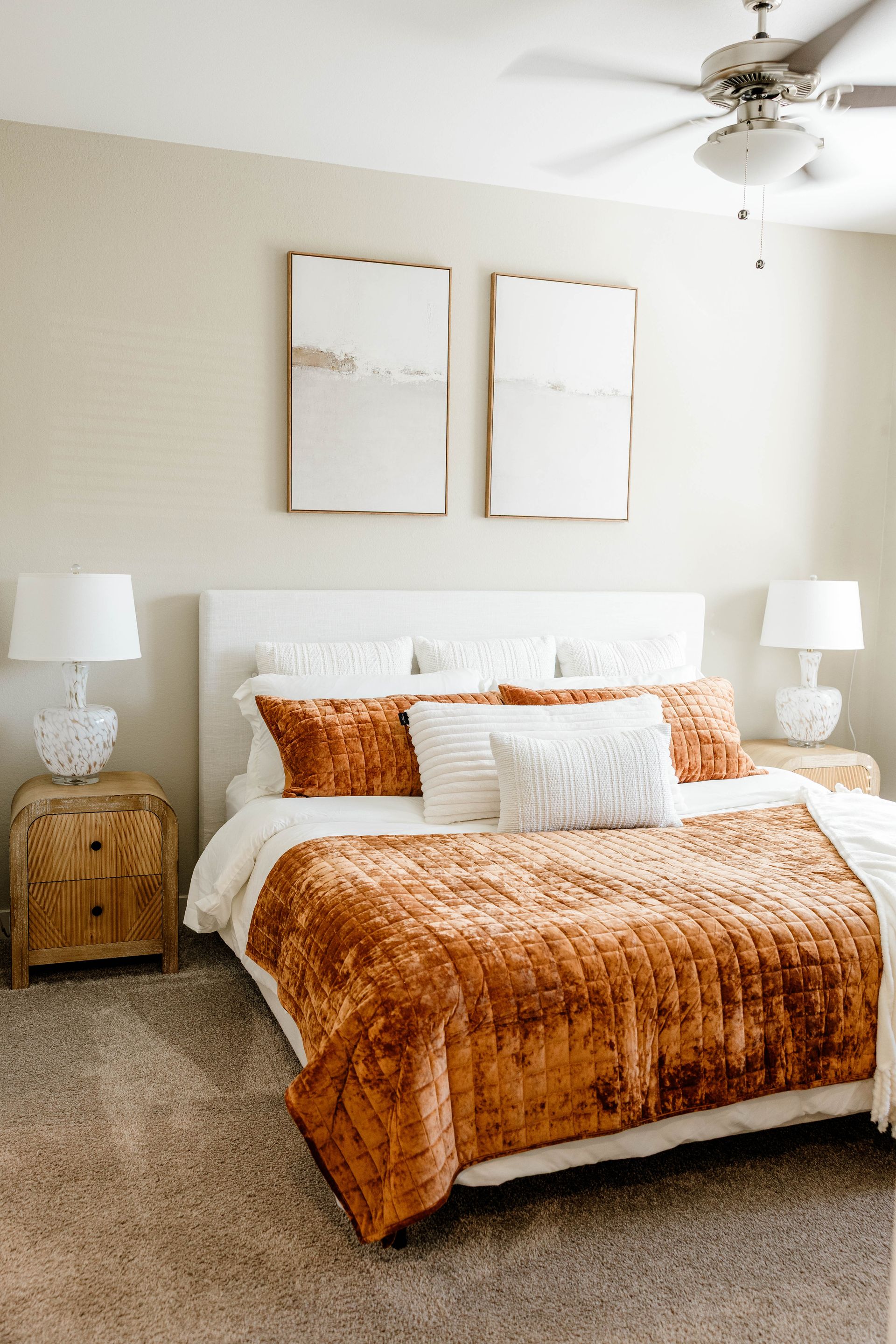Living room with beige sofa, blue artwork, and a dark wood coffee table, on a blue patterned rug.