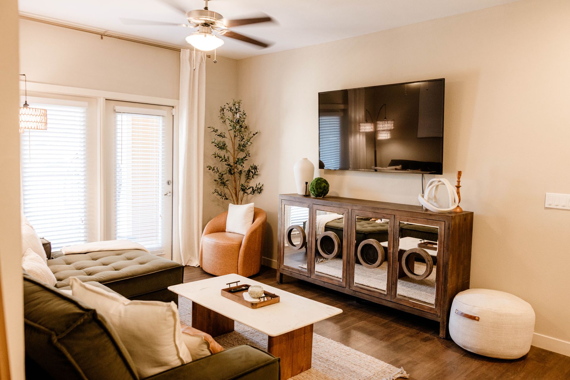 Modern kitchen with dining area; white cabinets, stainless steel appliances, wood floor.