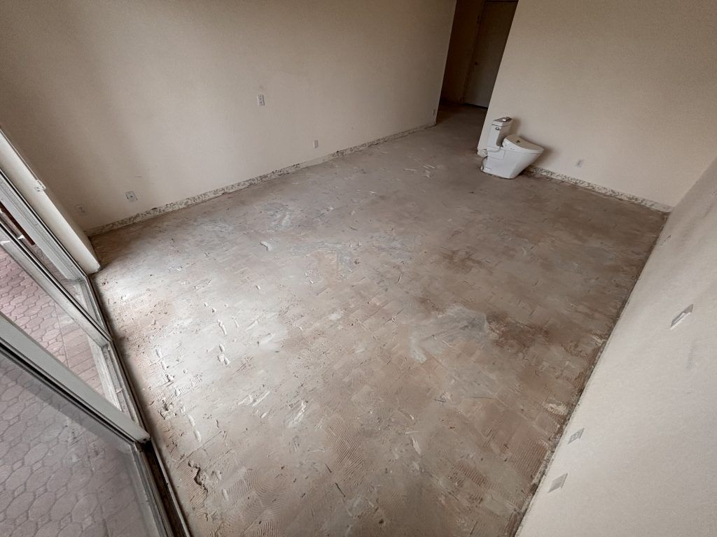 Empty room with cement floor, partially finished walls, and sliding glass door.