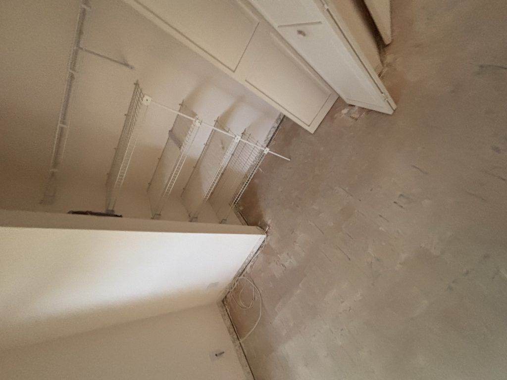 Empty closet with wire shelving and unfinished walls.