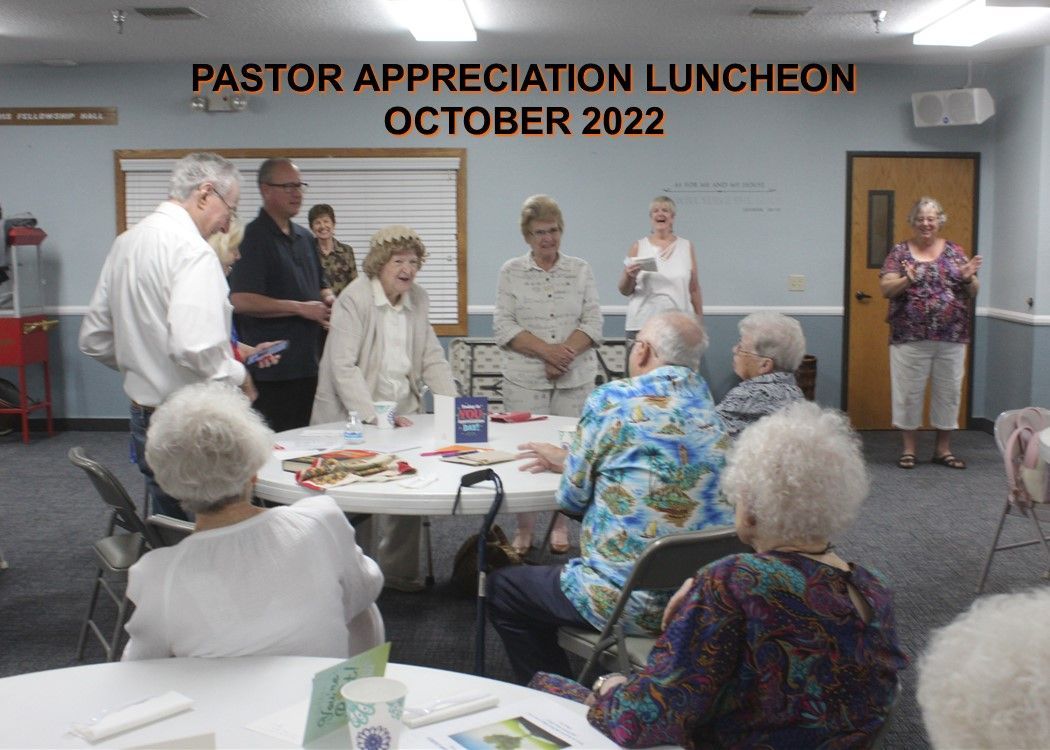 A group of people are sitting around a table at a pastor appreciation luncheon