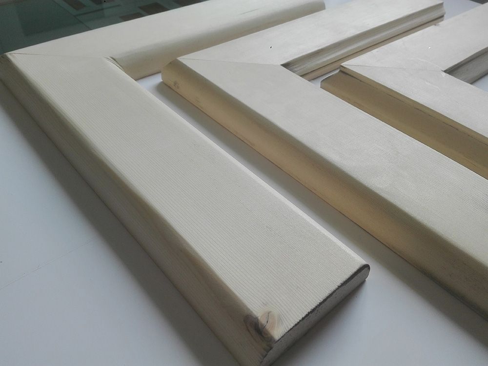 Tre pezzi di legno bianchi sono adagiati su una superficie bianca