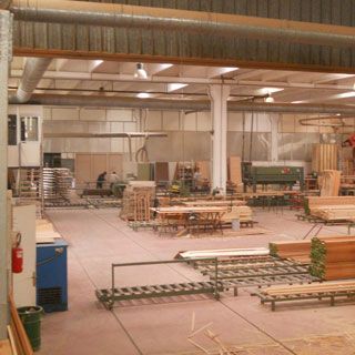 Un grande magazzino pieno di legna e macchinari