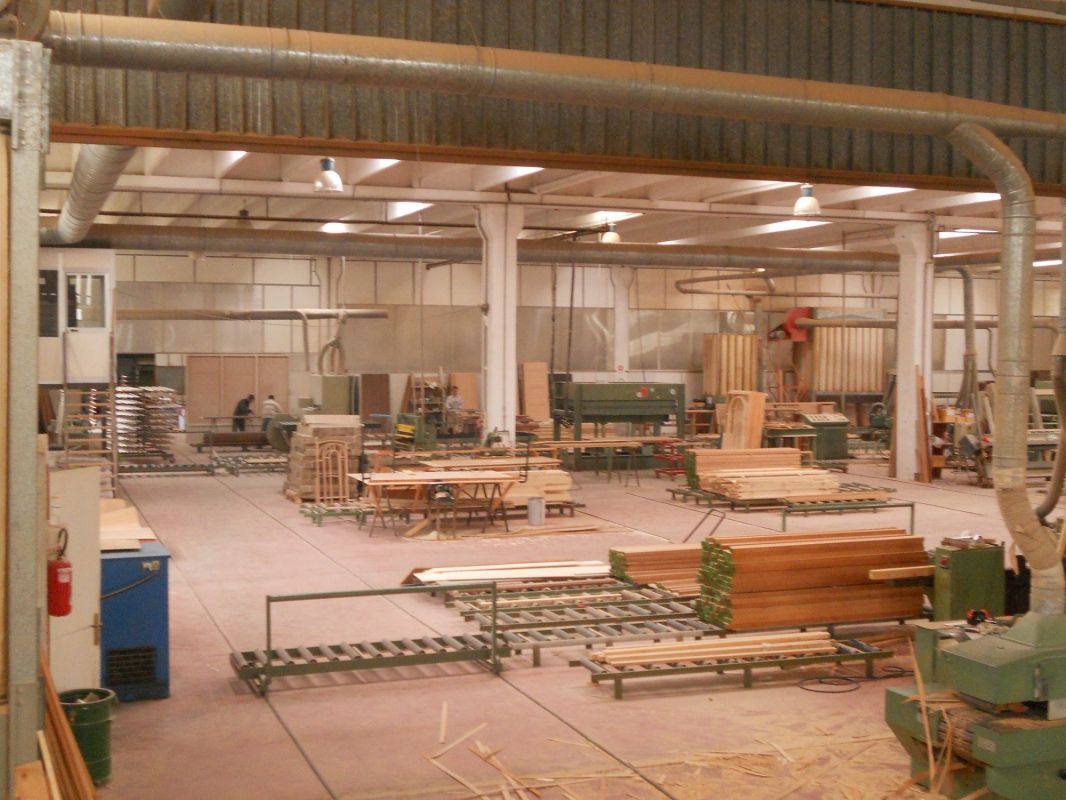 Un grande magazzino pieno di legna e macchinari.