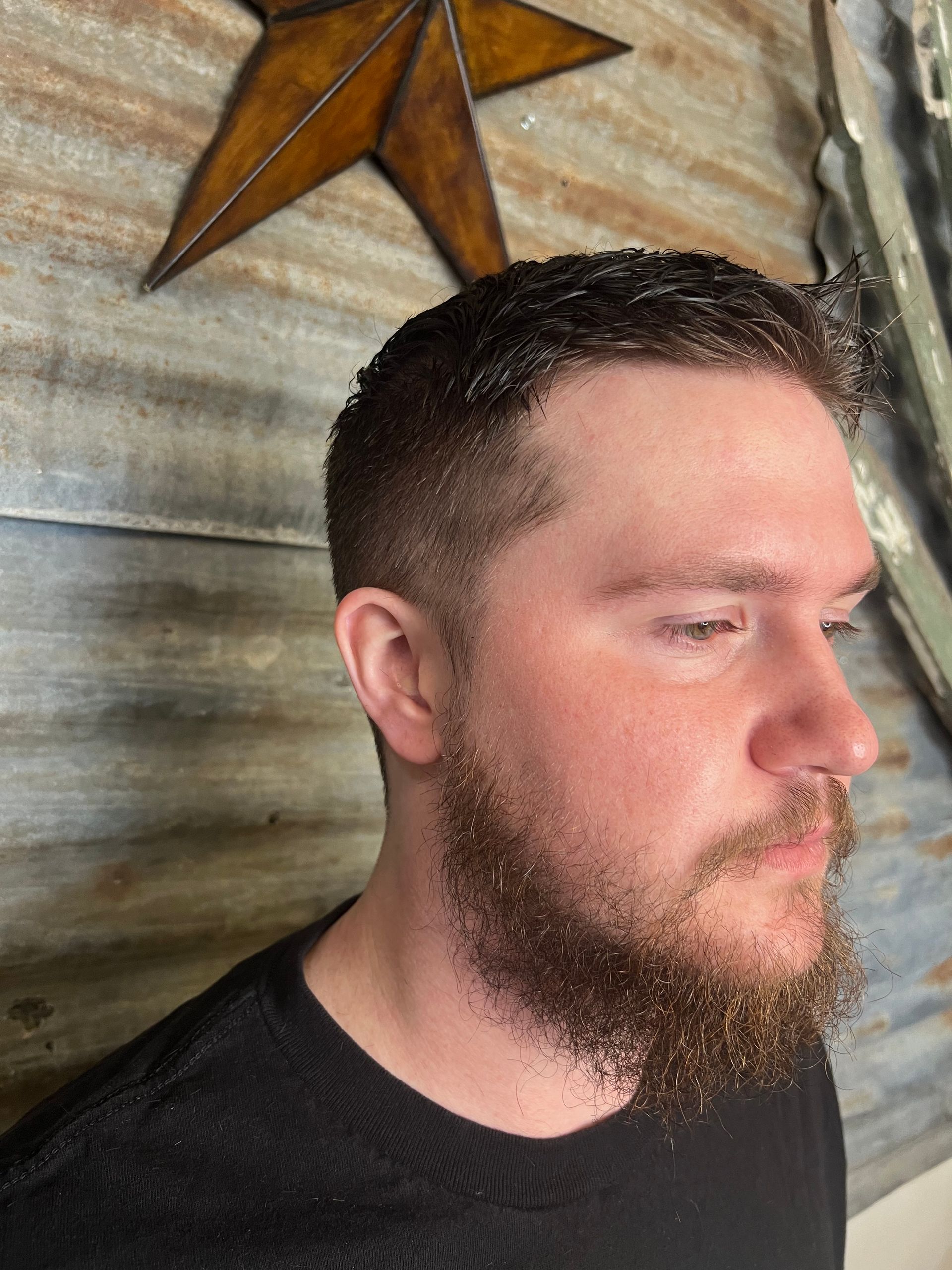 A man with a beard is wearing a black shirt.