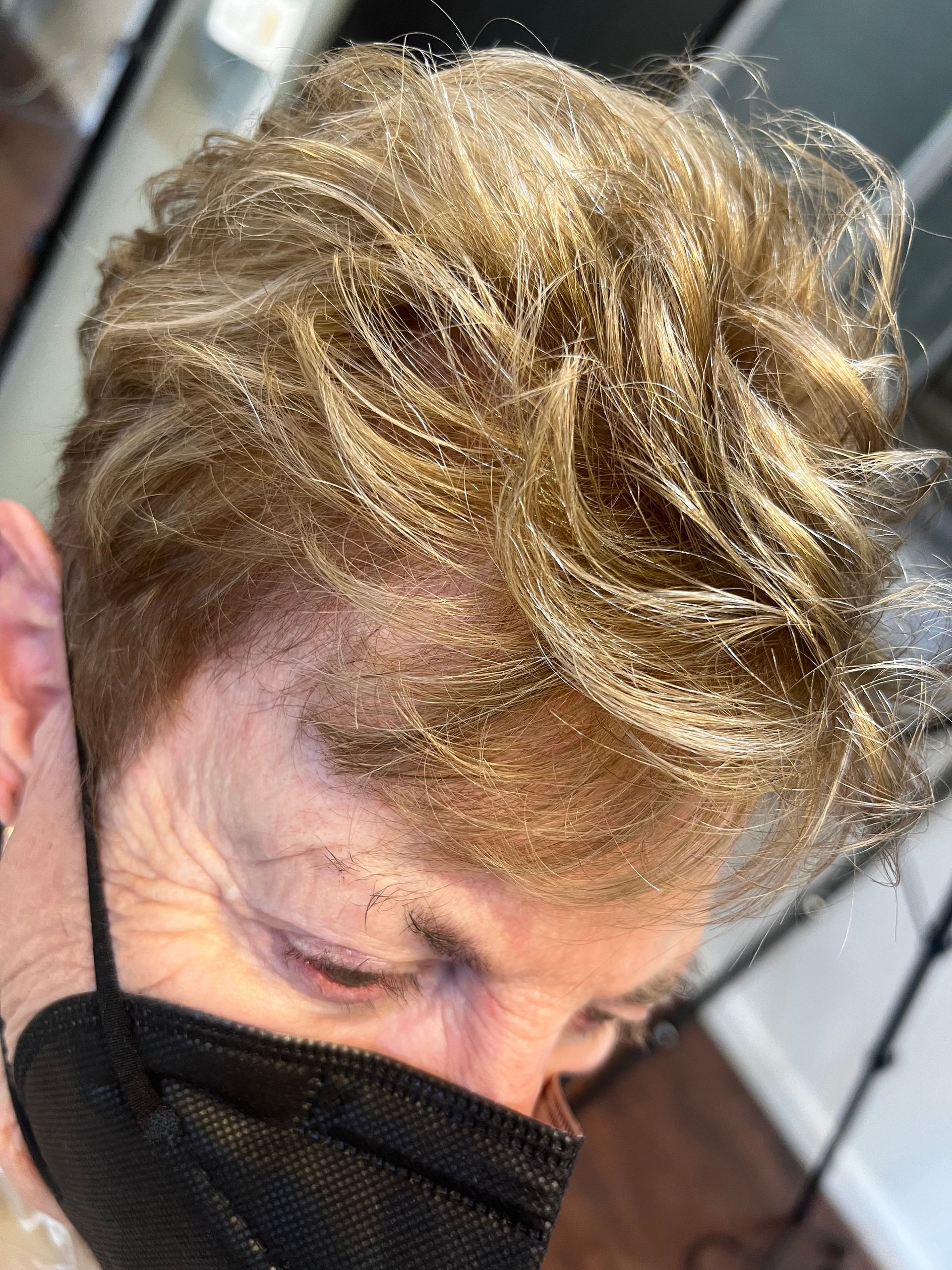 A close up of a woman wearing a black face mask.
