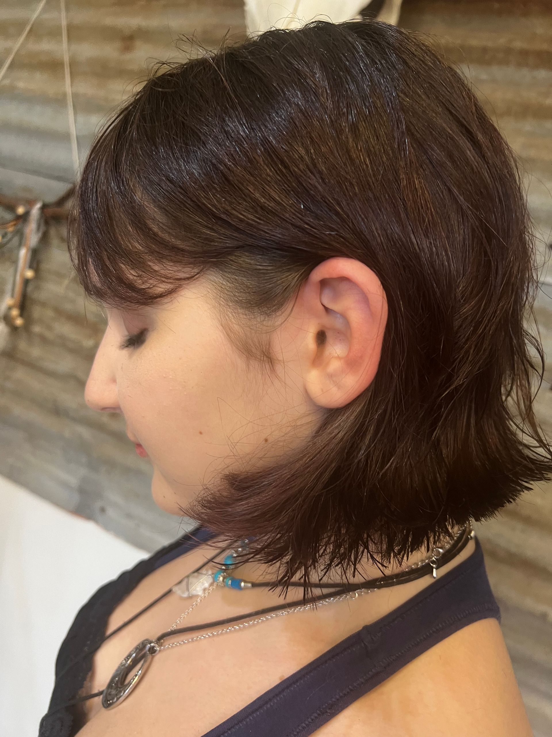 A close up of a woman 's hair with a necklace around her neck