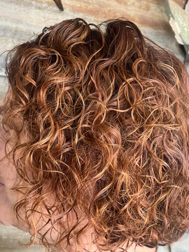 A close up of a woman 's curly hair.