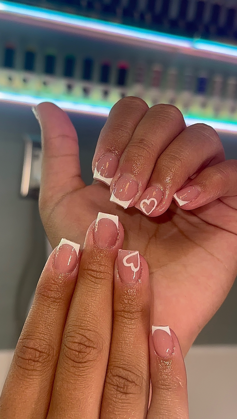 A close up of a person 's nails with a heart on them.