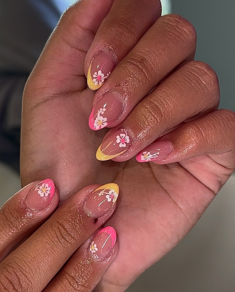 A close up of a person 's nails with flowers on them
