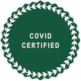 A green circle with white leaves around it that says `` covid certified ''.