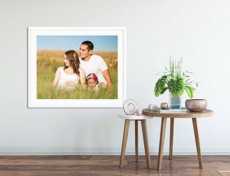 Family image framed, hanging on wall with tables on the floor