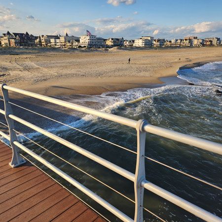 A View of a Beach From a Pier With a White Railing — Bangalow Electrical in Ocean Shores, NSW