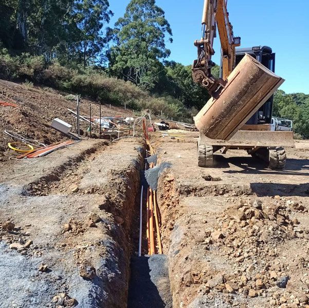 A Bulldozer is Digging a Hole in the Ground — Bangalow Electrical in Bangalow, NSW