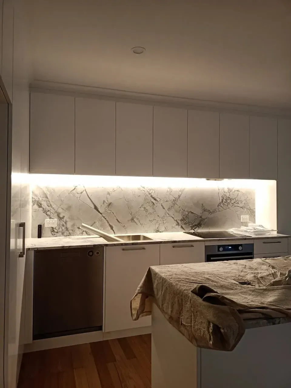 A Kitchen With White Cabinets and a Marble Counter Top — Bangalow Electrical in Bangalow, NSW