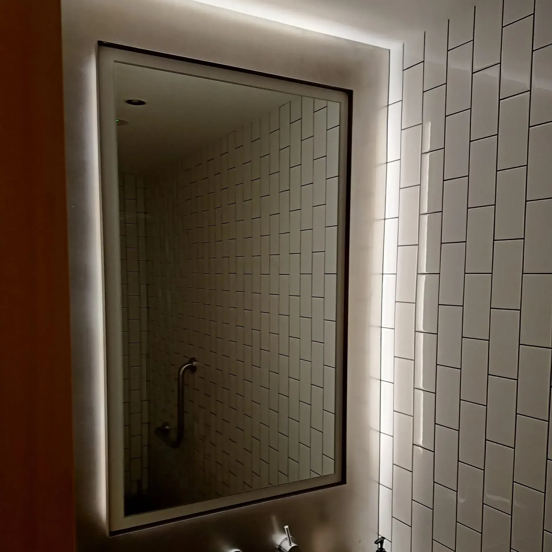 A Bathroom With White Tiles and a Large Mirror — Bangalow Electrical in Brunswick Heads, NSW