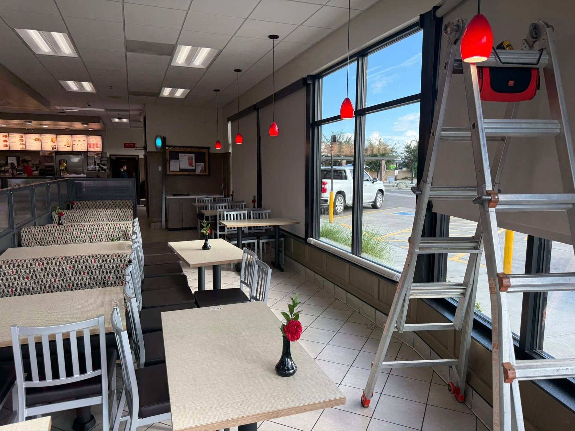 Interior of a Chick-fil-A restaurant, with tables, seating, and a ladder by the window.