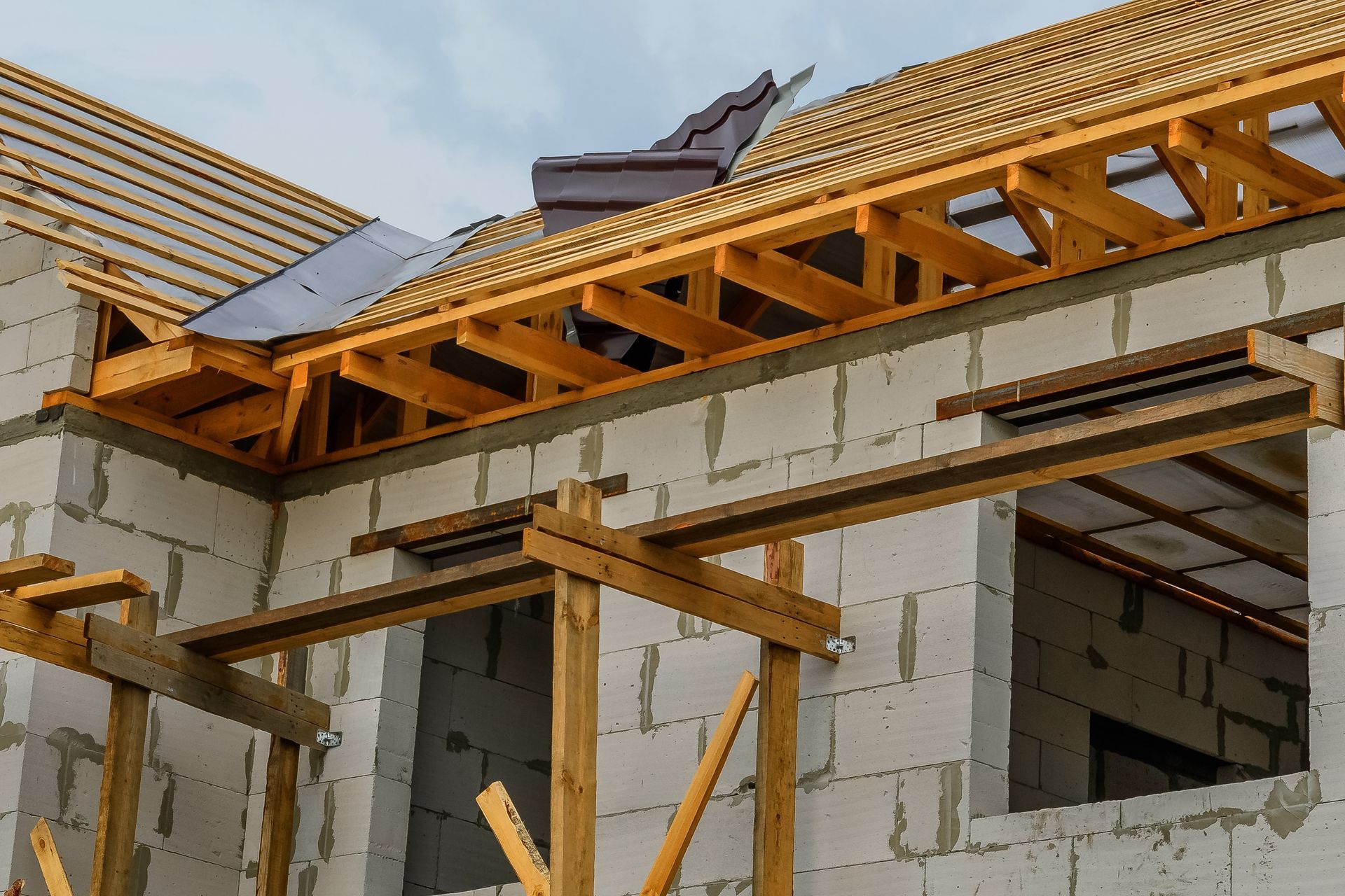 A house is being built with wooden beams and a wooden roof.