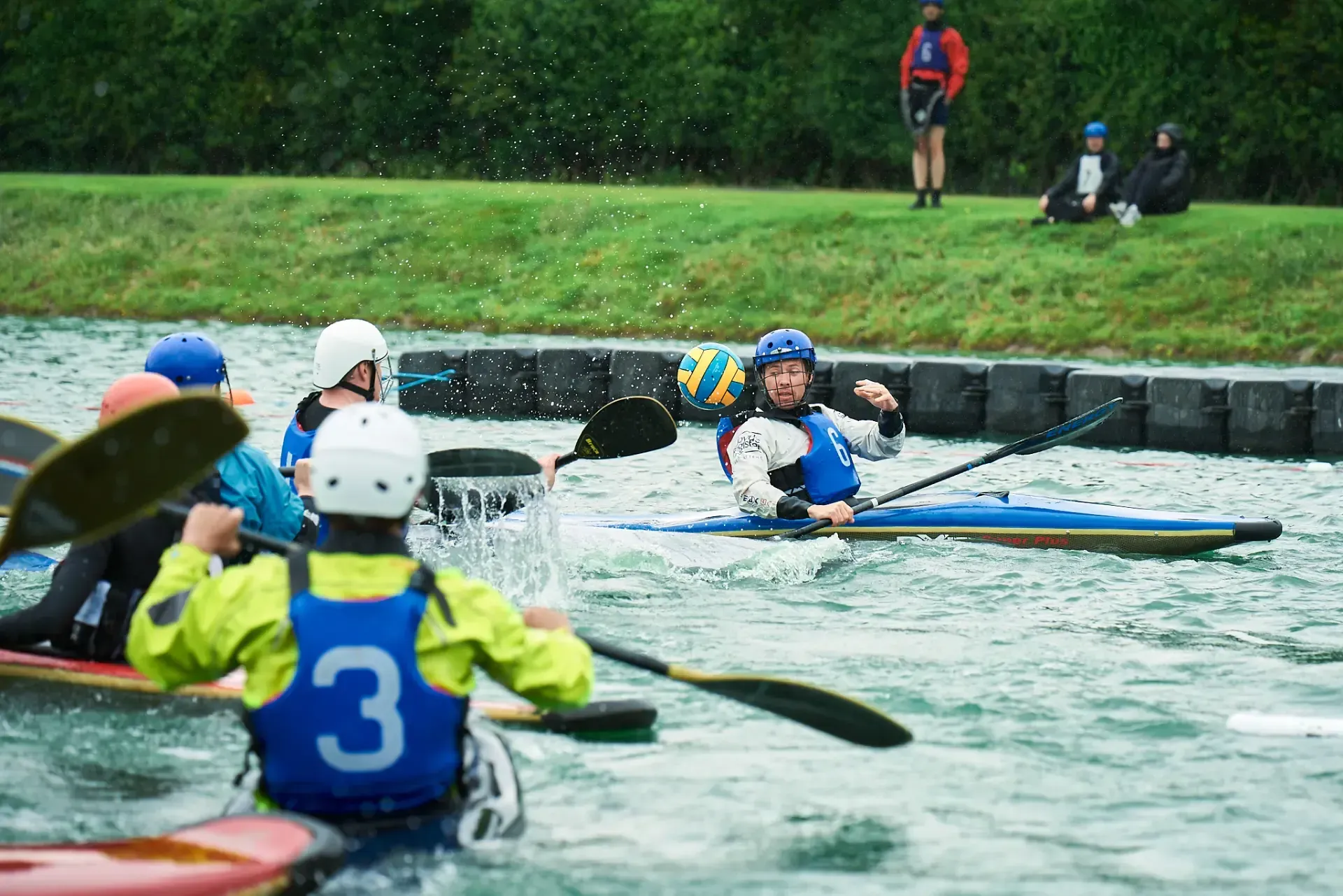 A group of people are rowing kayaks on a river.