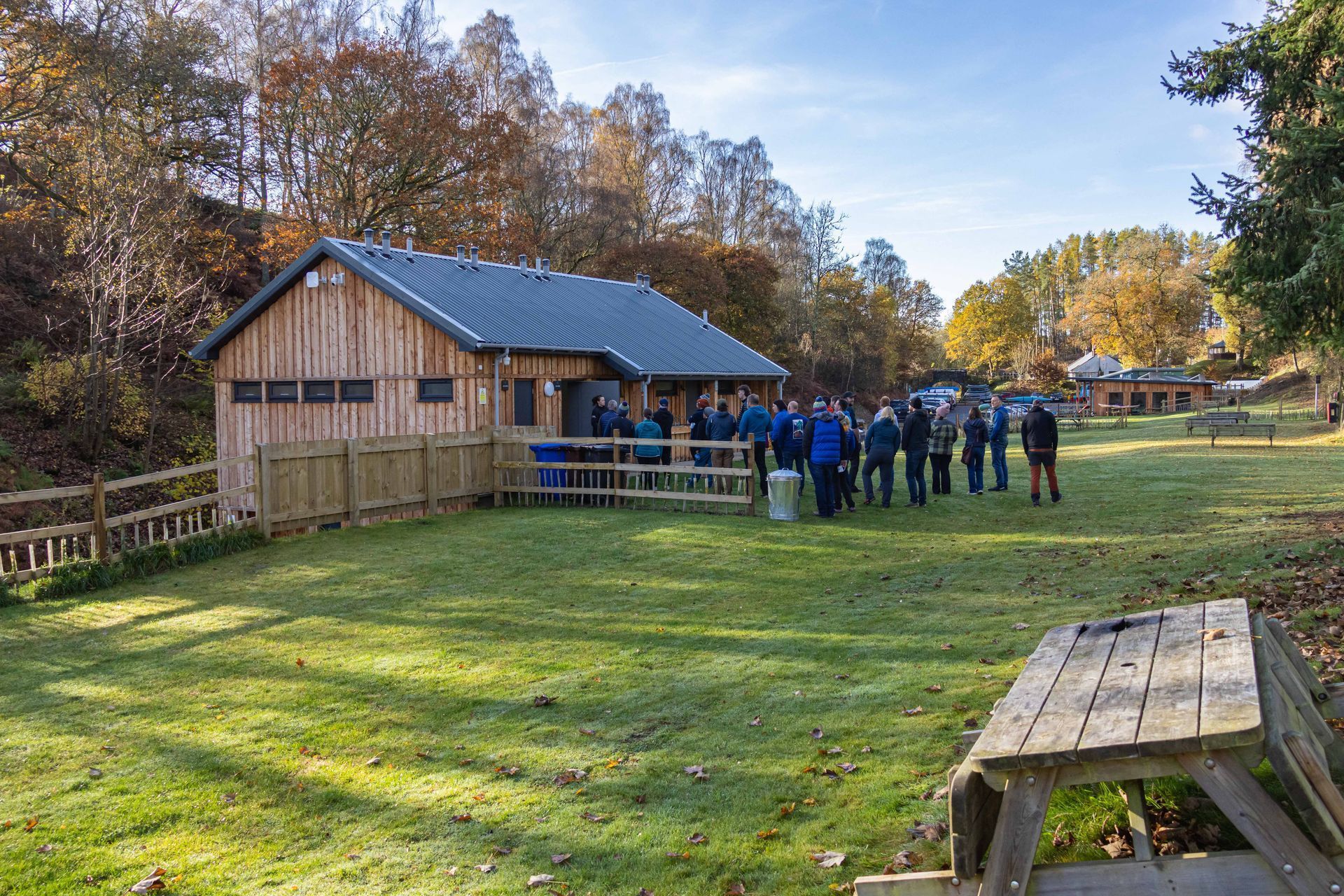A group of people are standing in front of a wooden building.