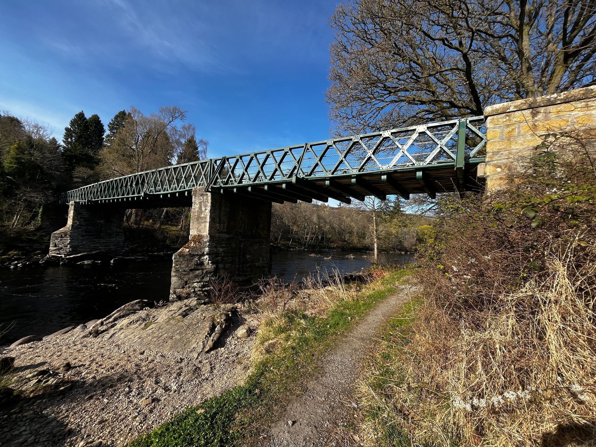 A bridge over a river with a path leading to it.
