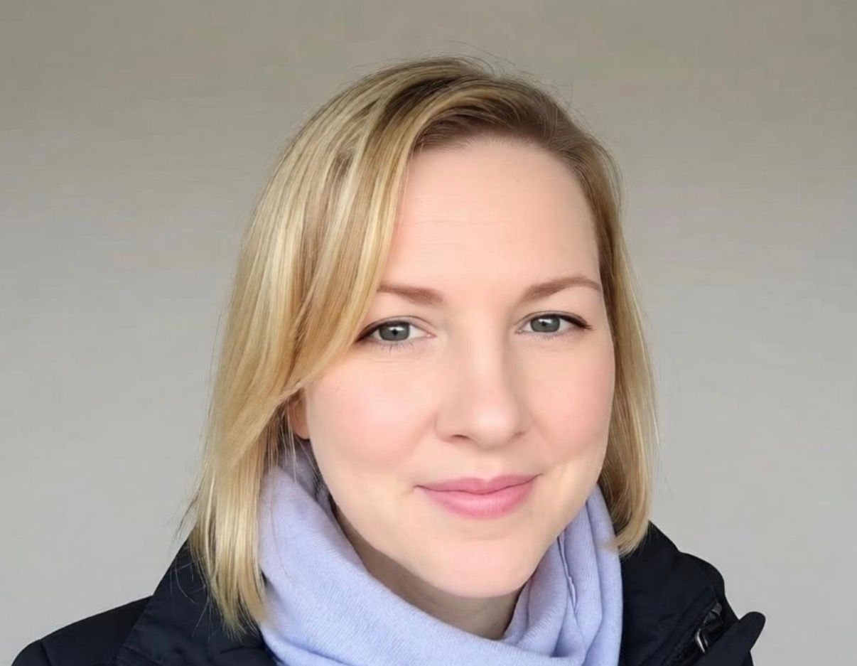 A man in a blue jacket is standing in front of a bicycle track.