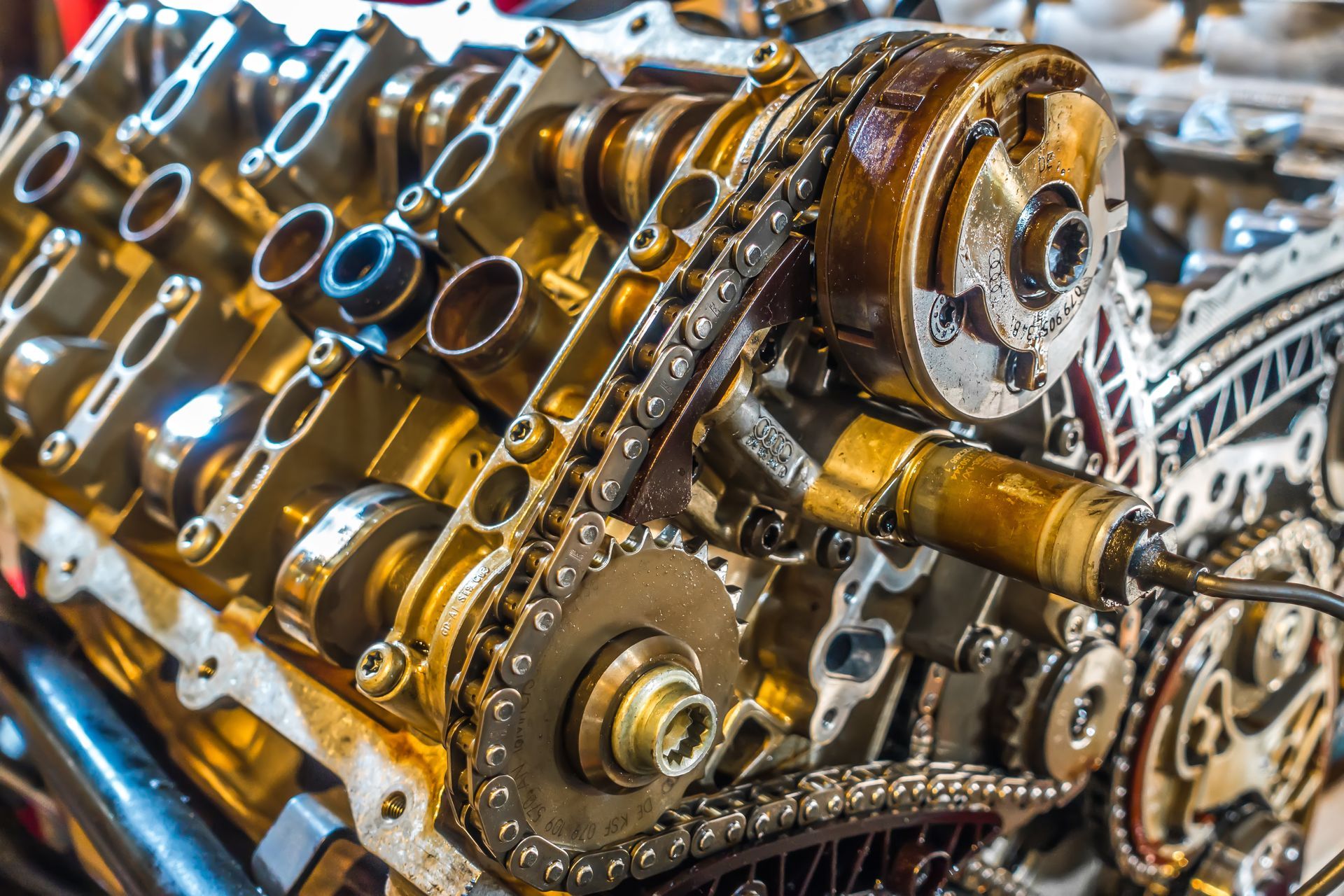 Close-up of an engine's internal components, including gears, chains, and camshafts. Visible oil Close-up of an engine's internal components, including gears, chains, and camshafts. Visible oil