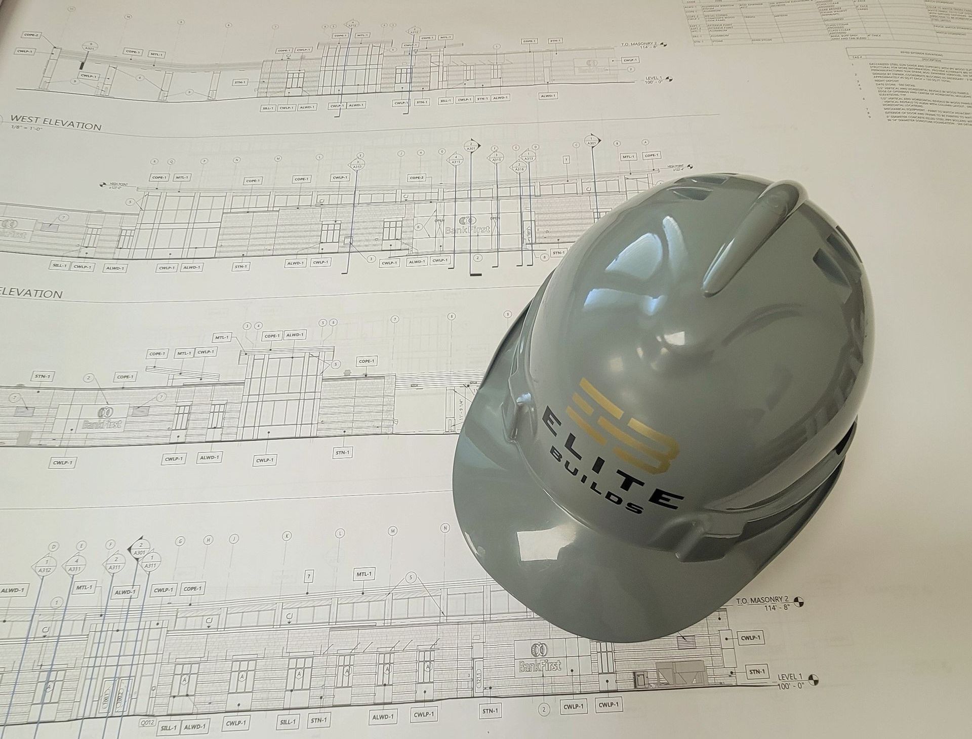 A Man Wearing a Hard Hat Is Working on A Stone Wall | Sheboygan, WI | Elite Builds