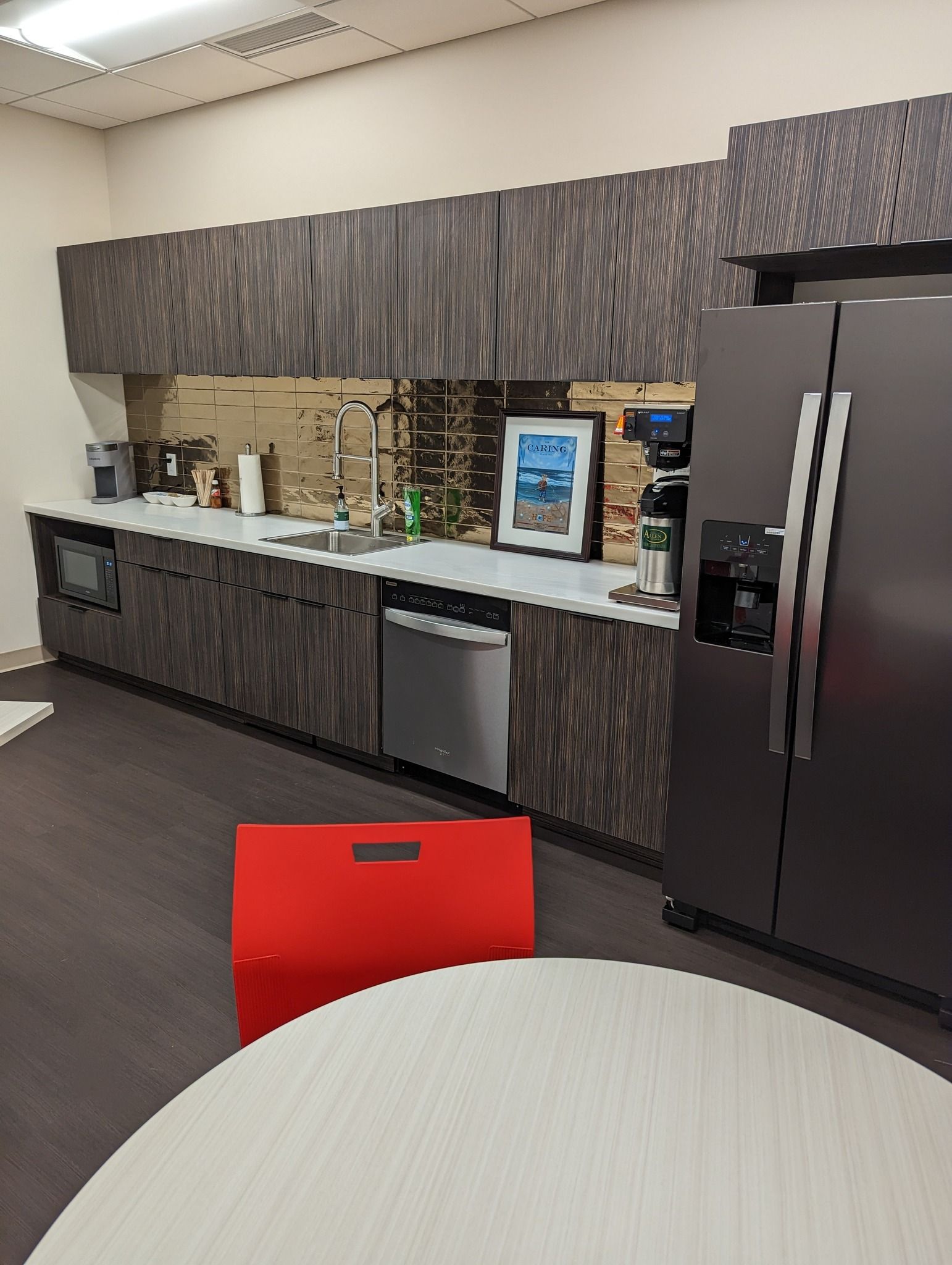Kitchen with dark cabinets, stainless steel appliances, and a red folding crate.