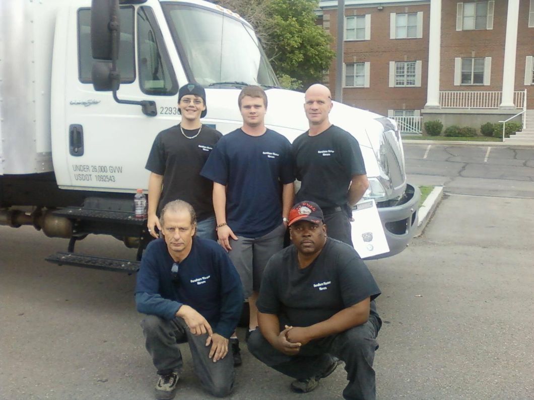 A group of men posing in front of a white truck
