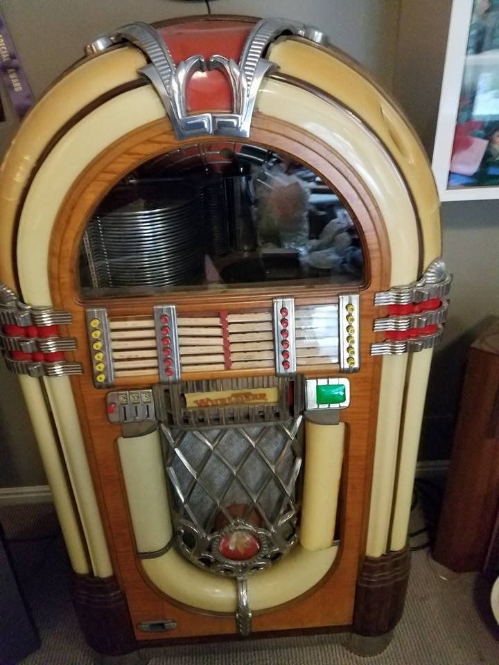 A jukebox is sitting on the floor in a room.