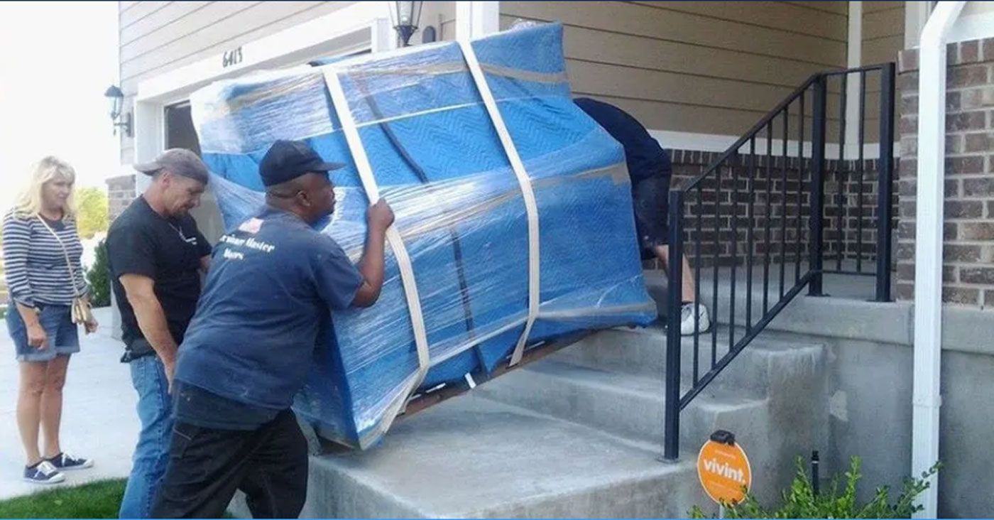 A group of men are moving a piano up the stairs of a house.
