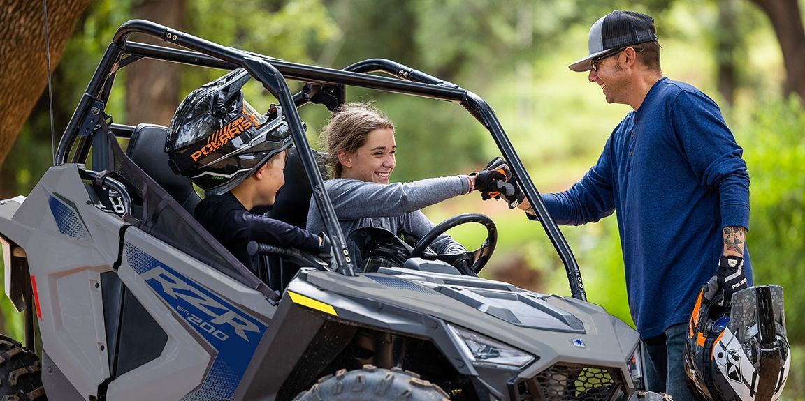 A man and two children are sitting in a atv.