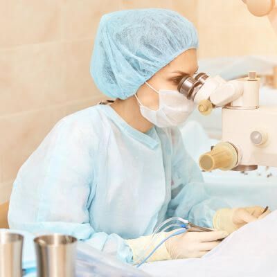 female ophthalmologist performing eye surgery