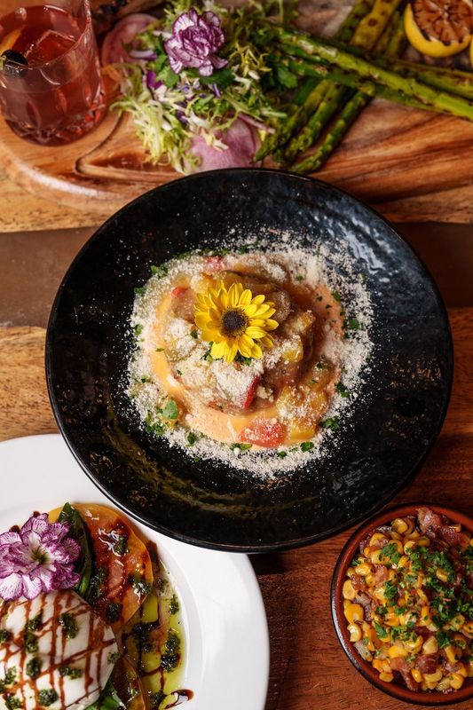 A table topped with plates of food and a cutting board.