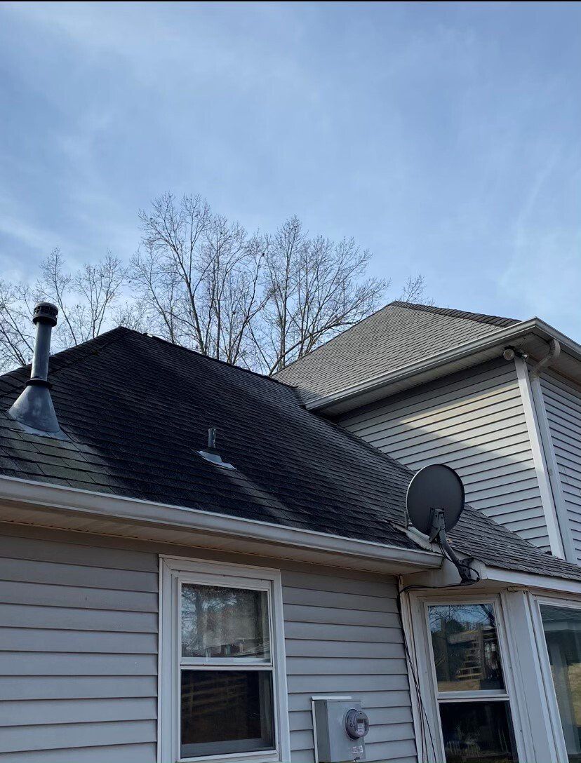 A white house with a satellite dish on the roof.