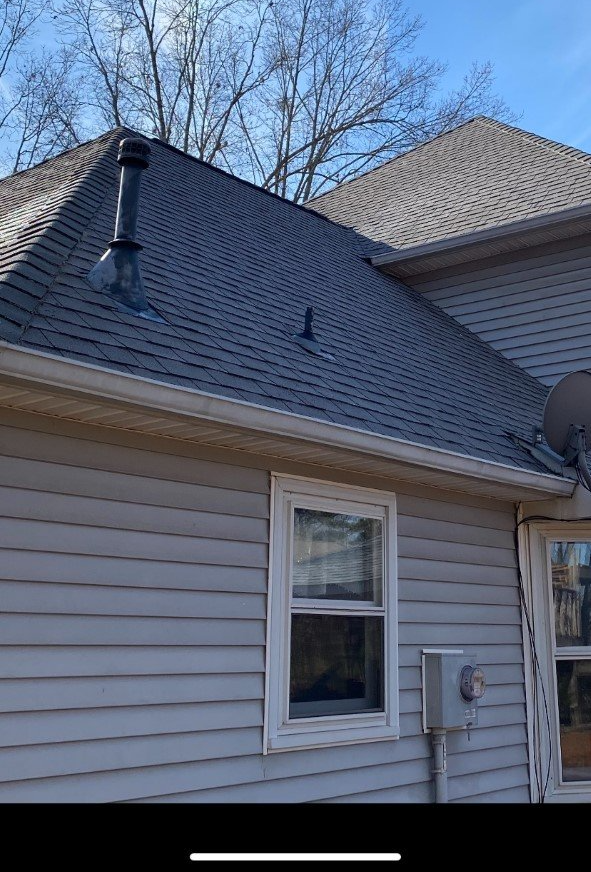 A house with a satellite dish on the roof and a window.