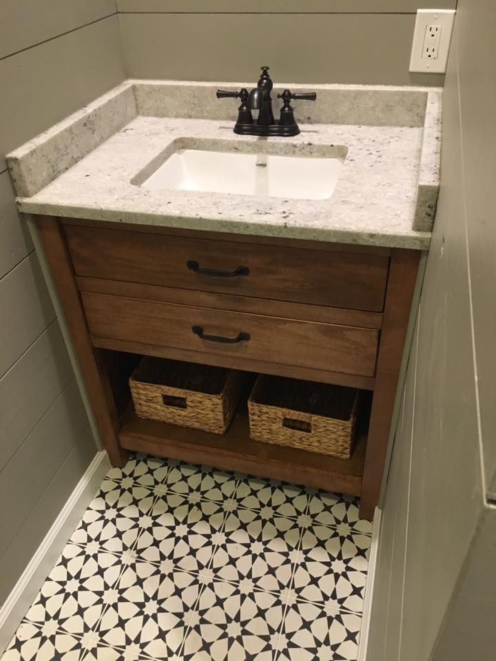 A bathroom sink with two baskets underneath it